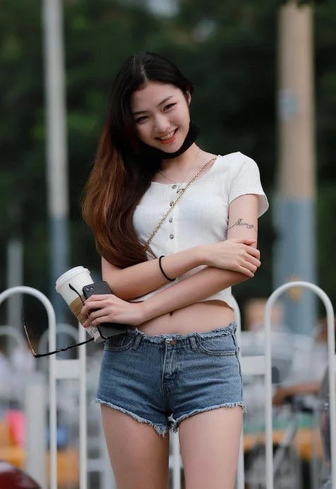 街拍：秋水伊人的美女，短款背心配白色短裤，尽显纤细美腿