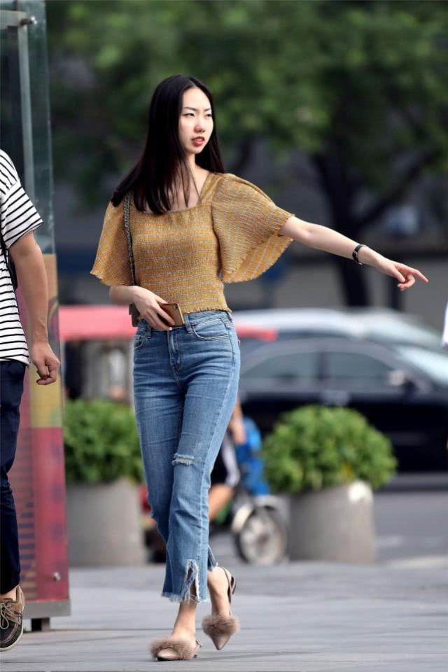 街拍：面带微笑气质大方的辣妈，黑色的牛仔裤搭配显瘦还优雅
