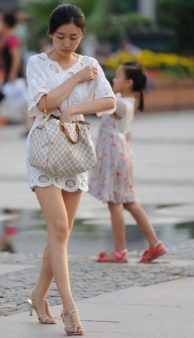 热情|街拍:白色镂空刺绣连衣裙搭配高跟凉鞋,热情活泼干净清爽。