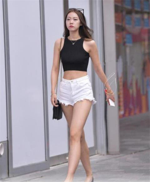 街拍秋水伊人的美女,身穿短款背心配白色短裤,时尚又靓丽