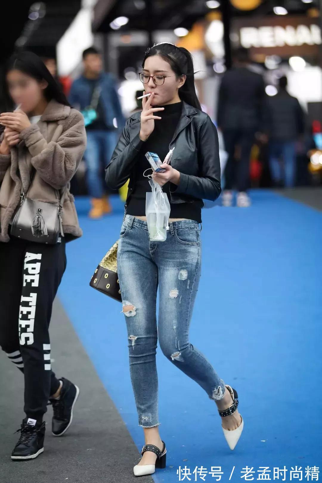 妹子 街拍:眼镜妹子身穿皮衣外套搭配破洞牛仔裤,英姿飒爽,霸气外露