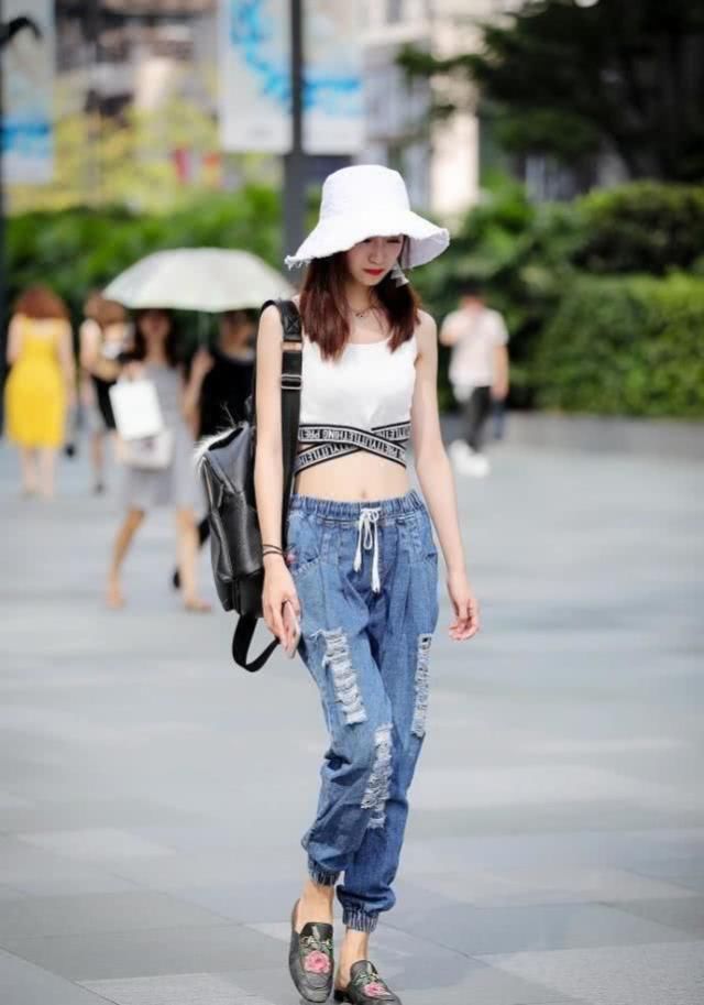 帅气大方的牛仔裤搭配显身姿，体现了美女的时髦气质与品位