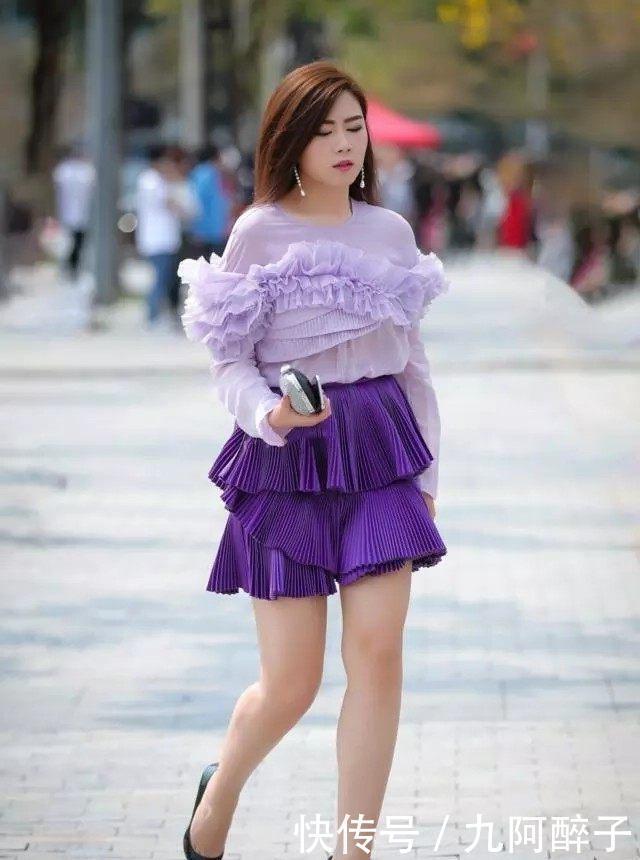 路人街拍靓女穿着一件浅黄色的连衣裙,显得非常妩媚