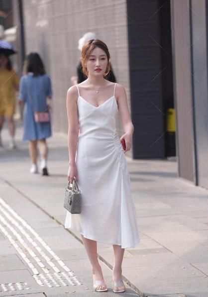 吊带连衣裙，配上高跟鞋和灰色包包，显示出了美女的“青春气质”