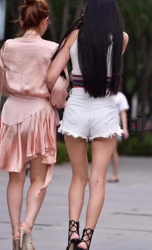 身穿|街拍:两个漂亮的小姐姐一起逛街,一个身穿短裤,一个像裹了睡衣