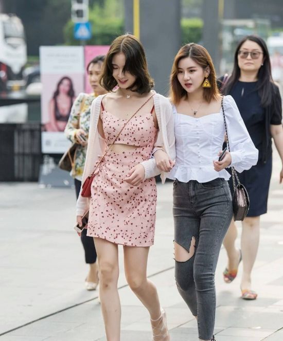 街拍:白色连衣裙穿出了美女的好身材,撩发的姿势也很是动人