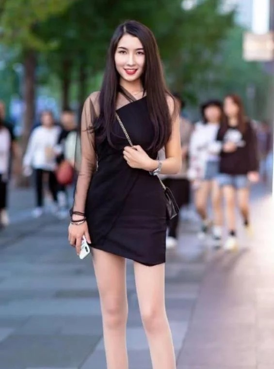 街拍:面带笑容的美女,身穿黑色连衣裙,时尚唯美气质