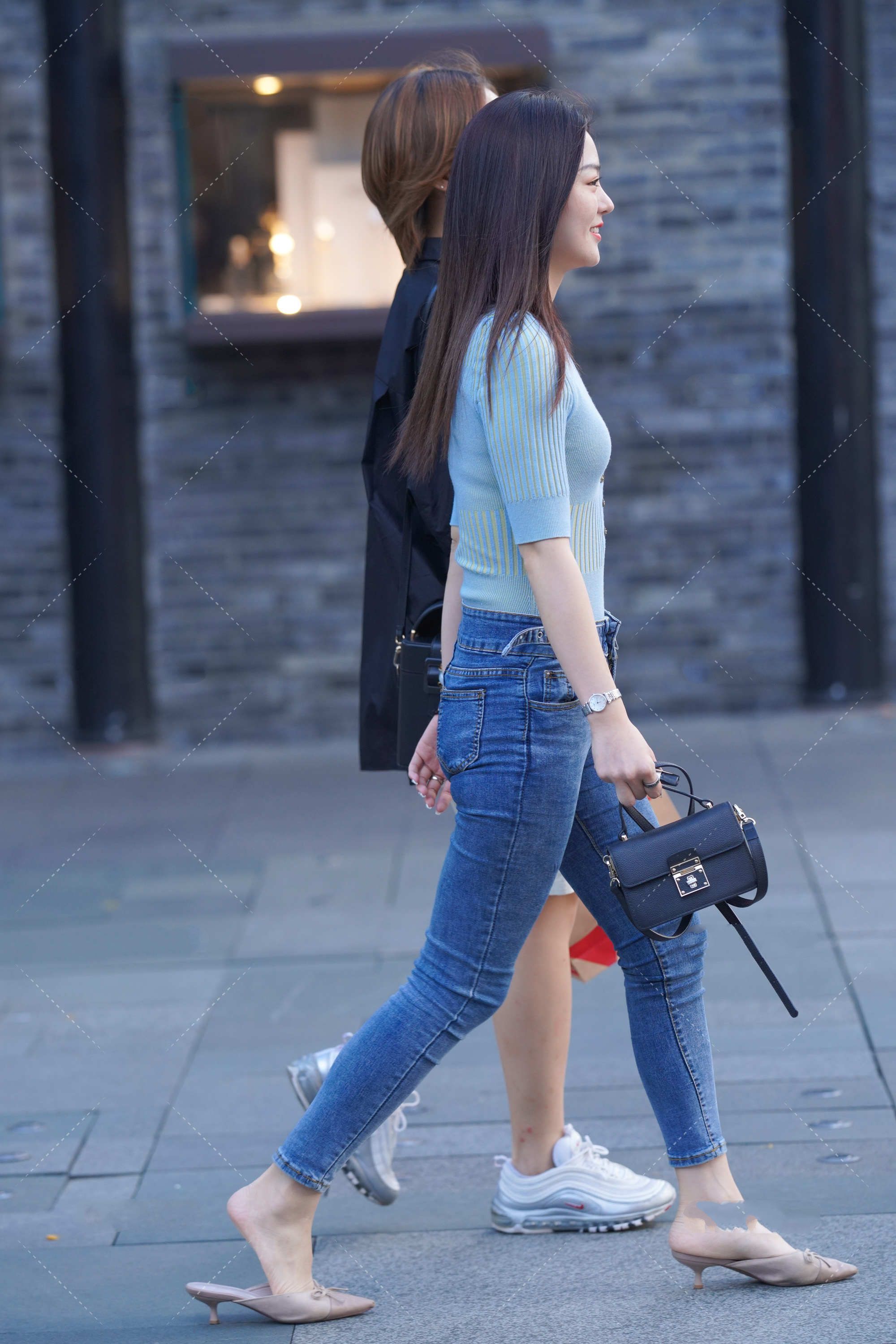 蓝绿色修身上衣搭配深色牛仔裤，手拿黑色手提包，清爽简约的搭配