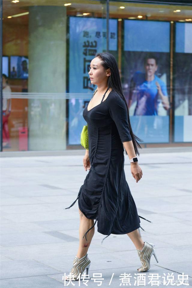 微胖身材的姑娘，穿着黑色连衣裙，搭配银色露趾细高跟踝靴