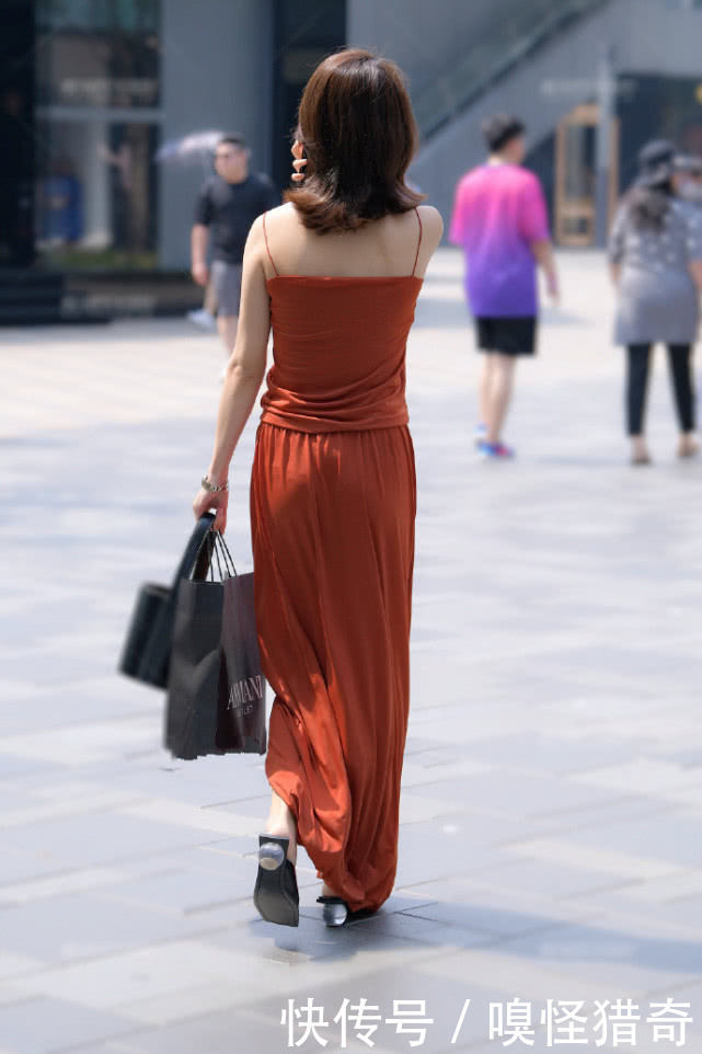 配手|街拍美女:橘色连衣长裙配手包 小姐姐翻翘的卷发让人更添魅力