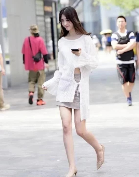 街拍：小姐姐身穿时尚白上衣 ，腰部镂空系带和衣襟，个性又时尚