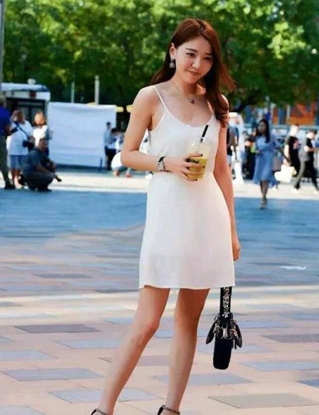 路人街拍，美女穿着一件v领的吊带，为自身的美丽加分