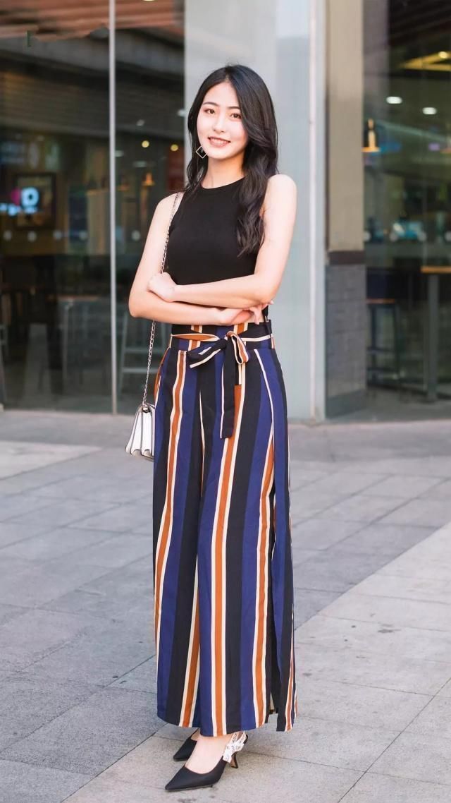 街拍图一颜值很高的小姐姐，背心搭配长裤很时尚，走路带风