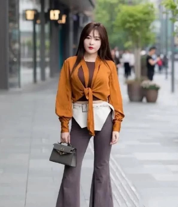 街拍:小姐姐身穿红色无袖上衣,搭配白色的长裤,造型很时尚