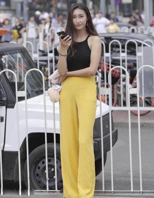 街拍“芒果黄长裤”出街,黑色露脐T恤尽显好身材,忍不住偷瞄