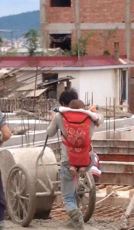 干活|爸爸背着孩子在工地干活的照片火了,网友:他的名字叫“父亲”