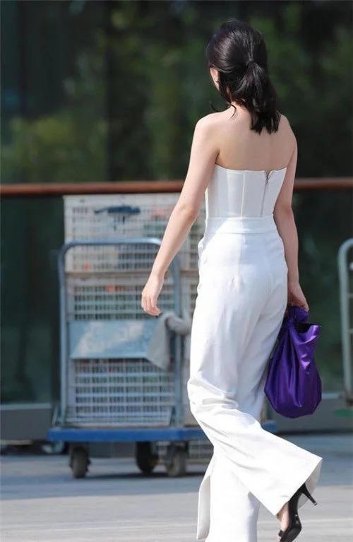 街拍:小姐姐扎着俏皮丸子头,身穿格子吊带短裙,减龄大方