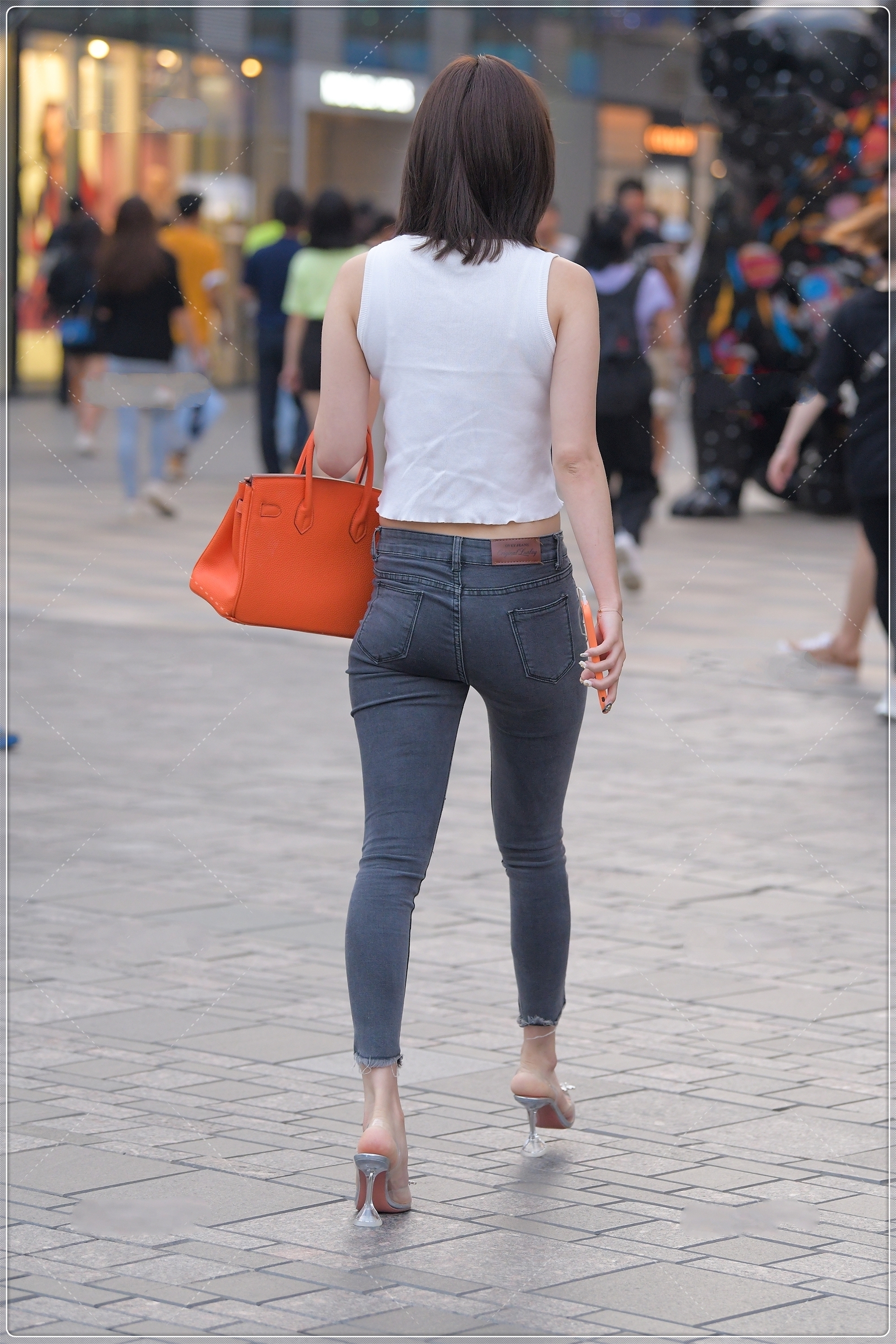 修身牛仔裤 夏季简单的白色背心,搭配露膝牛仔裤很时髦,简约时尚