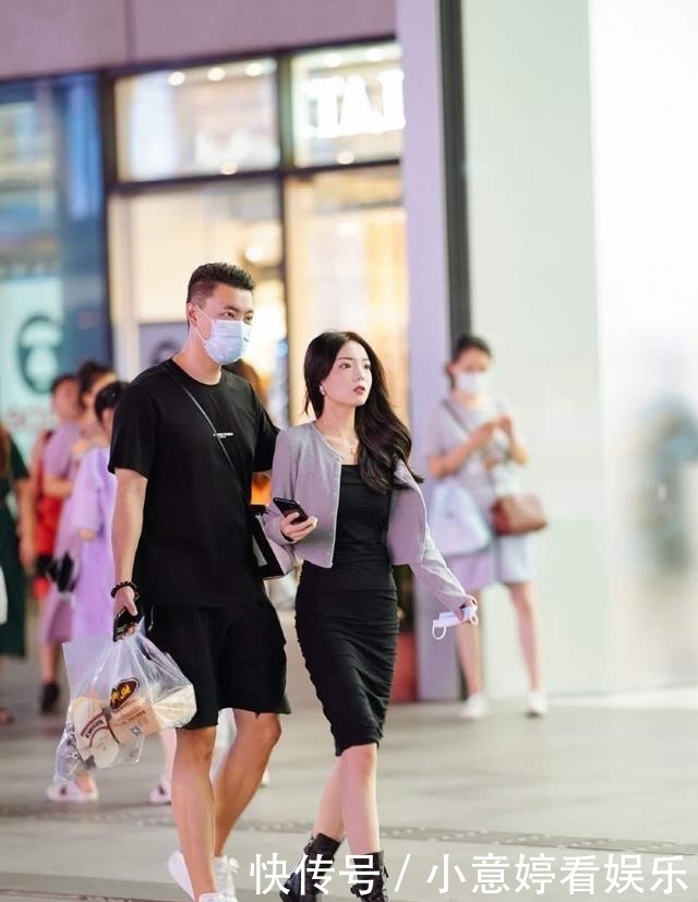 街拍：小姐姐穿墨绿色的开叉连衣裙，男朋友存托下显得大方又靓丽