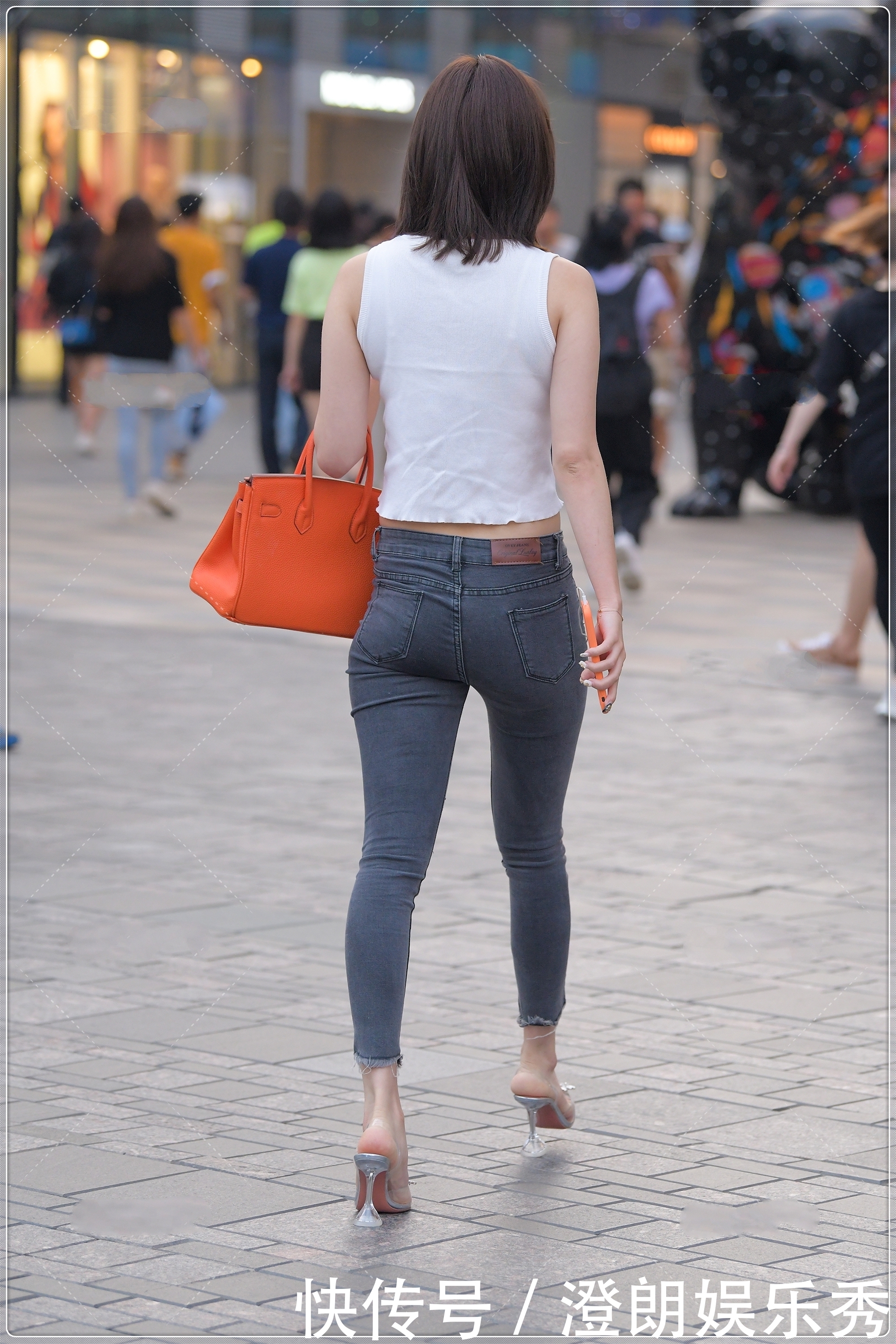 街拍美女简单的白色背心,搭配露膝牛仔裤很时髦,简约时尚