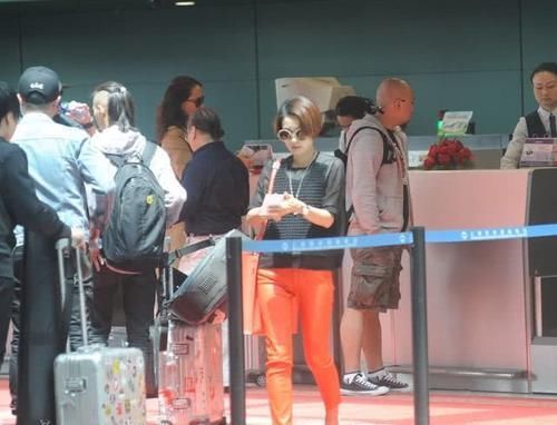 马伊琍穿黑色上衣，搭橙红色的休闲裤，打扮时髦且拉风！