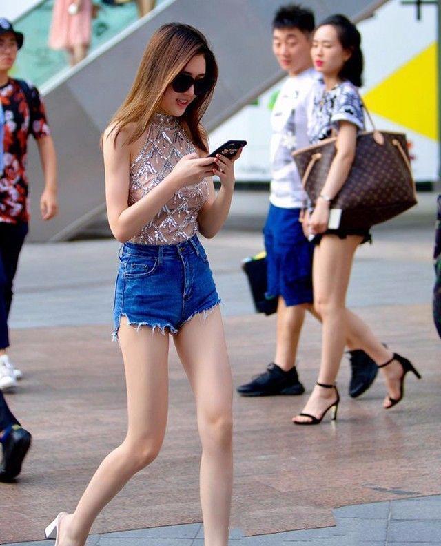 热裤 小姐姐身穿挂脖上衣,搭配牛仔热裤,发型做更很时尚