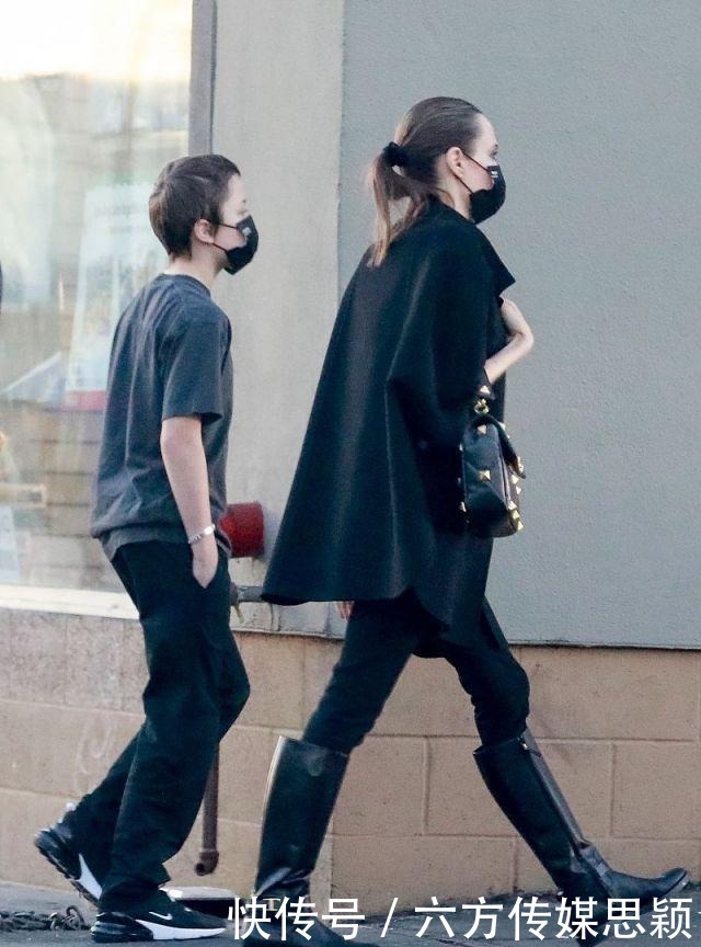 安吉丽娜·朱莉穿黑色斗篷上衣搭配细腿裤,和儿子逛街,真潇洒
