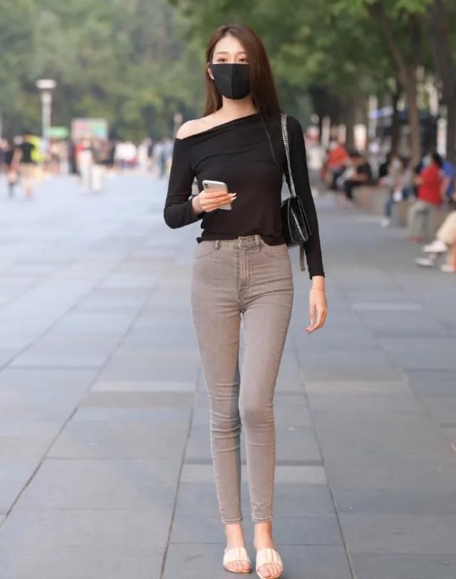  斜肩|黑色斜肩T恤，搭配灰色修身牛仔裤，修饰出甜美的身姿