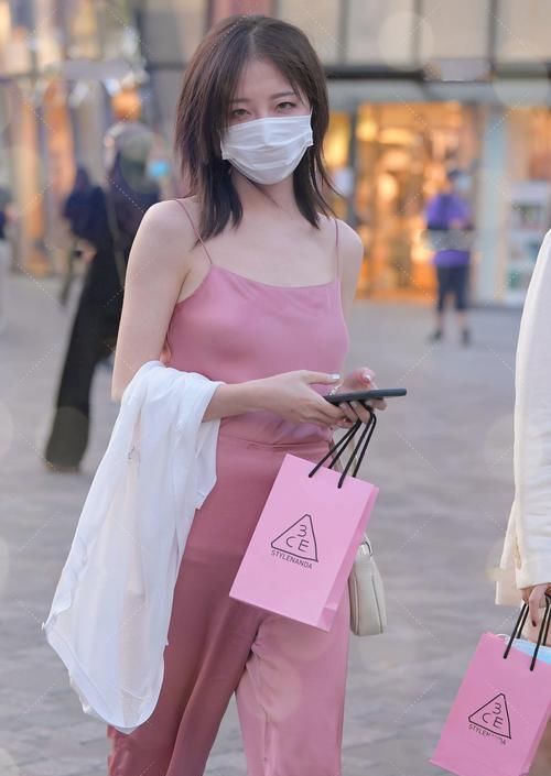 粉色真丝套装外搭白色针织衫，质感轻薄，高级优雅