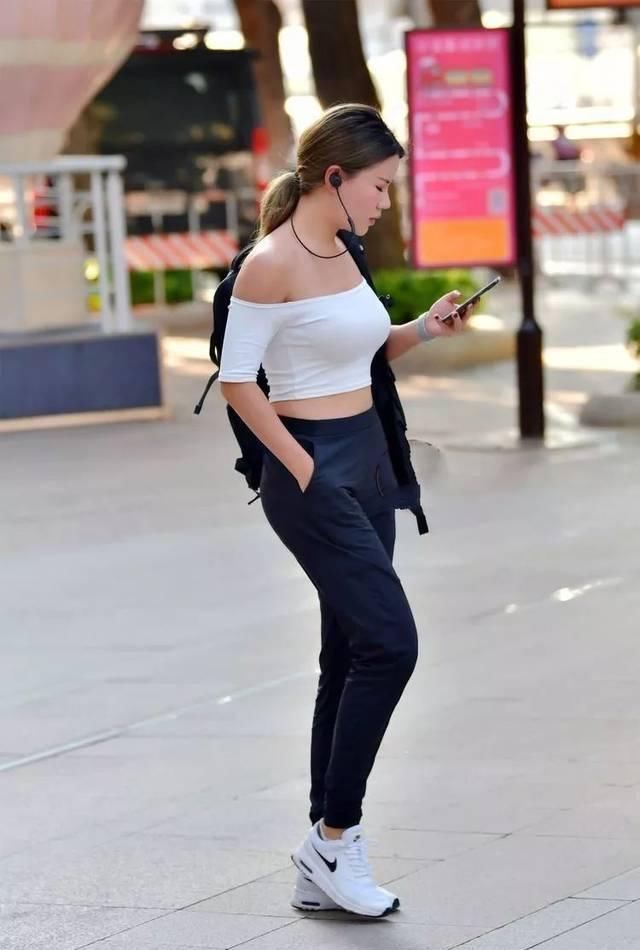 街拍牛仔短裤搭配黑色吊带背心,精致装扮为气质加分