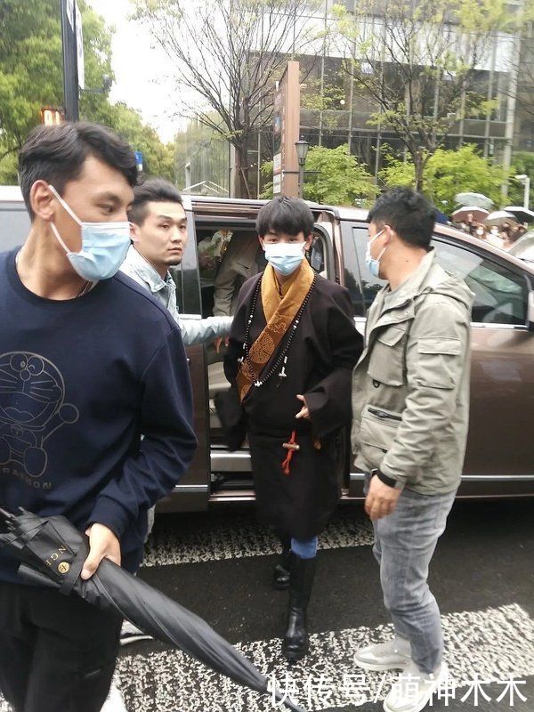 丁真首次亮相上海时装周，换上全套妆发造型看秀，为设计师献花