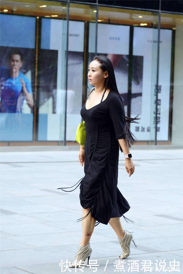 微胖身材的姑娘，穿着黑色连衣裙，搭配银色露趾细高跟踝靴