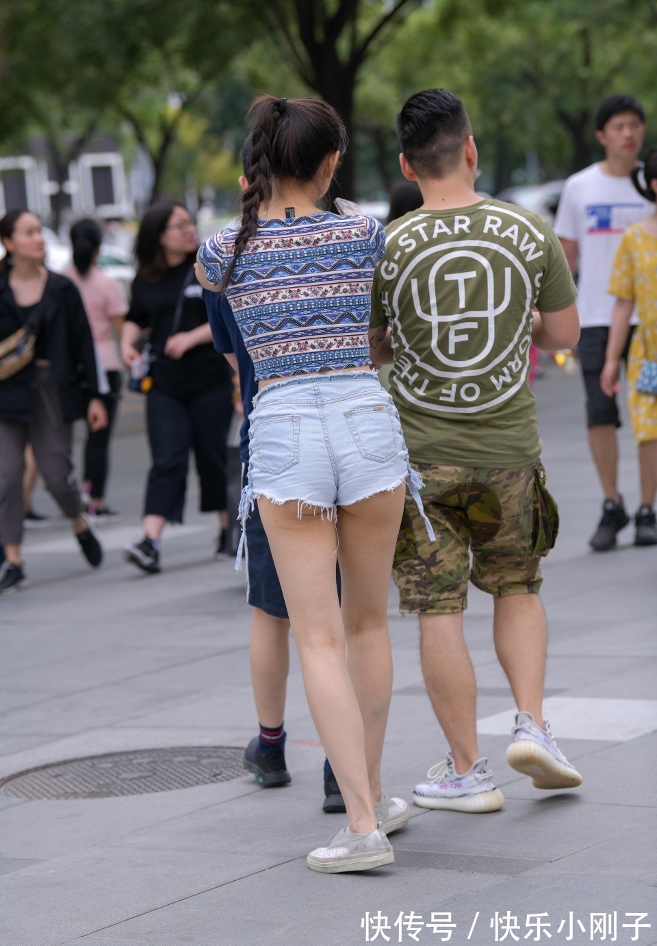 牛仔短裤|笑容灿烂的小姐姐，身穿有特色的短袖，搭配牛仔短裤，和朋友一起逛街显得很时尚