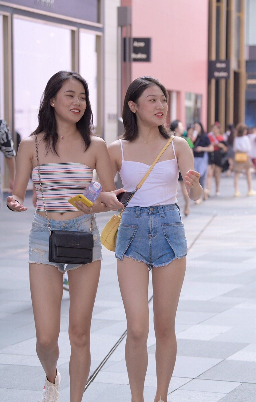 街拍 吊带、短裤、小白鞋,两个美女的服饰搭配相似度很高,真是好闺蜜