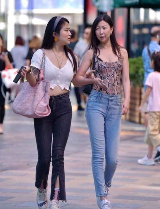 气质|街拍:身材高挑的美女,米黄色上衣配橘红色休闲裤,气质十足