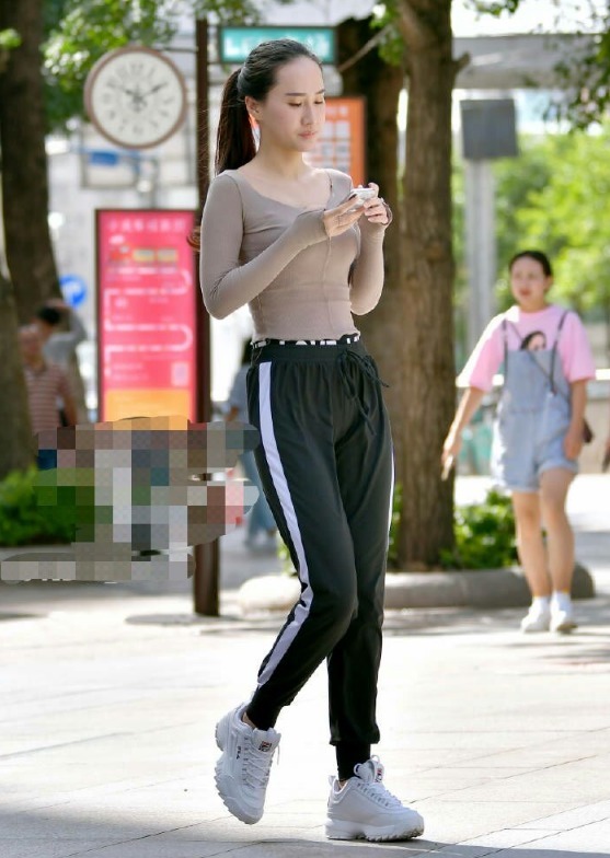 运动裤|街拍杏色打底衫搭配黑色运动裤,尽显女性高挑性感身姿!