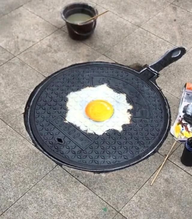 画板$美术生在井盖上画煎蛋,井盖变身平底锅,成画让人看饿了