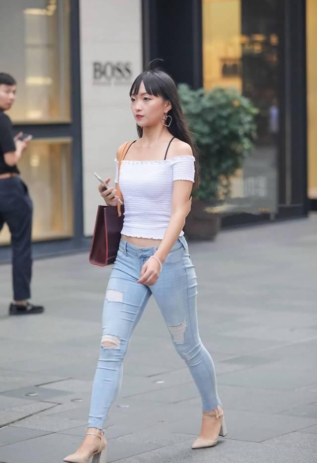 街拍|街拍美女破洞紧身牛仔裤搭配白色漏肩针织衫,很素雅的小姐姐