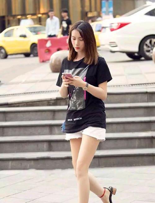 舒适|街拍小姐姐一件黑色半袖上衣宽松舒适,搭配白色短裤显得休闲风