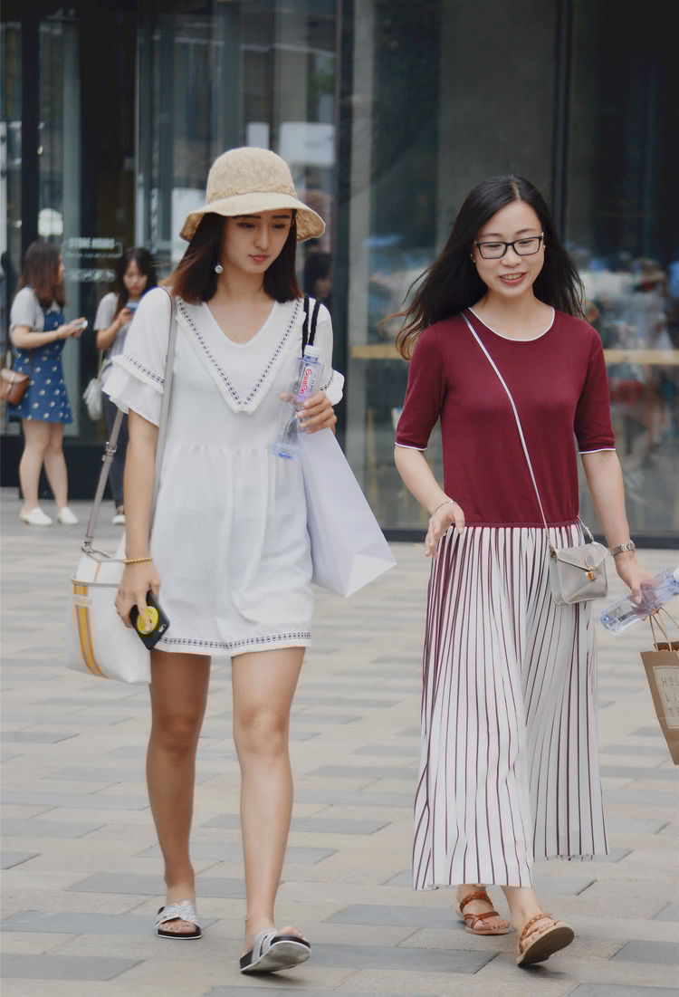 街拍:小美女身穿挂脖吊带裙装尽显傲人身姿,洁白肌肤,美极了