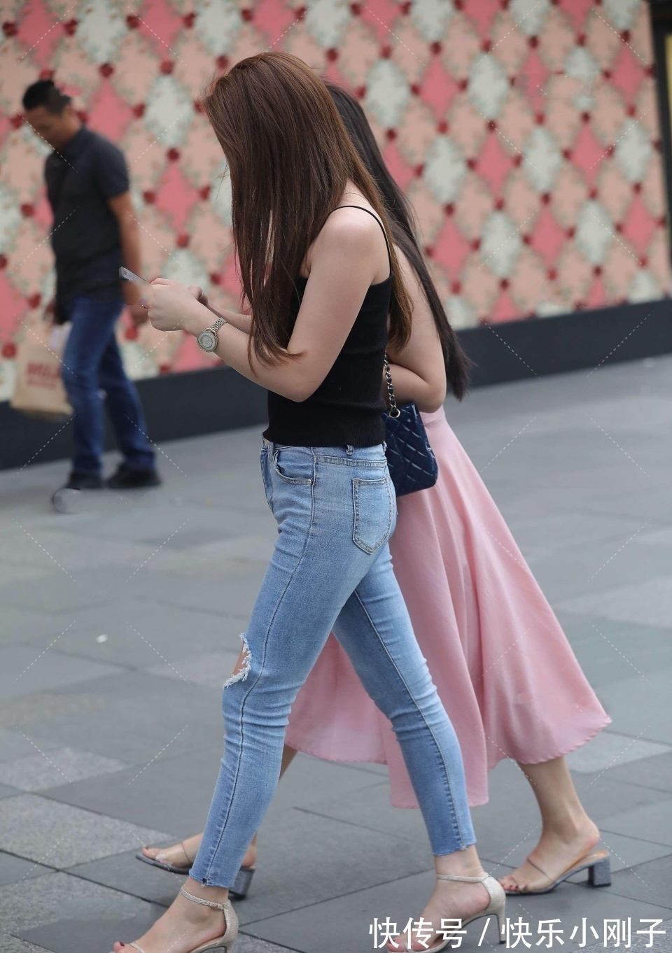 紧身牛仔裤 小姐姐身穿黑色吊带,搭配蓝色紧身牛仔裤,看上去时尚大方