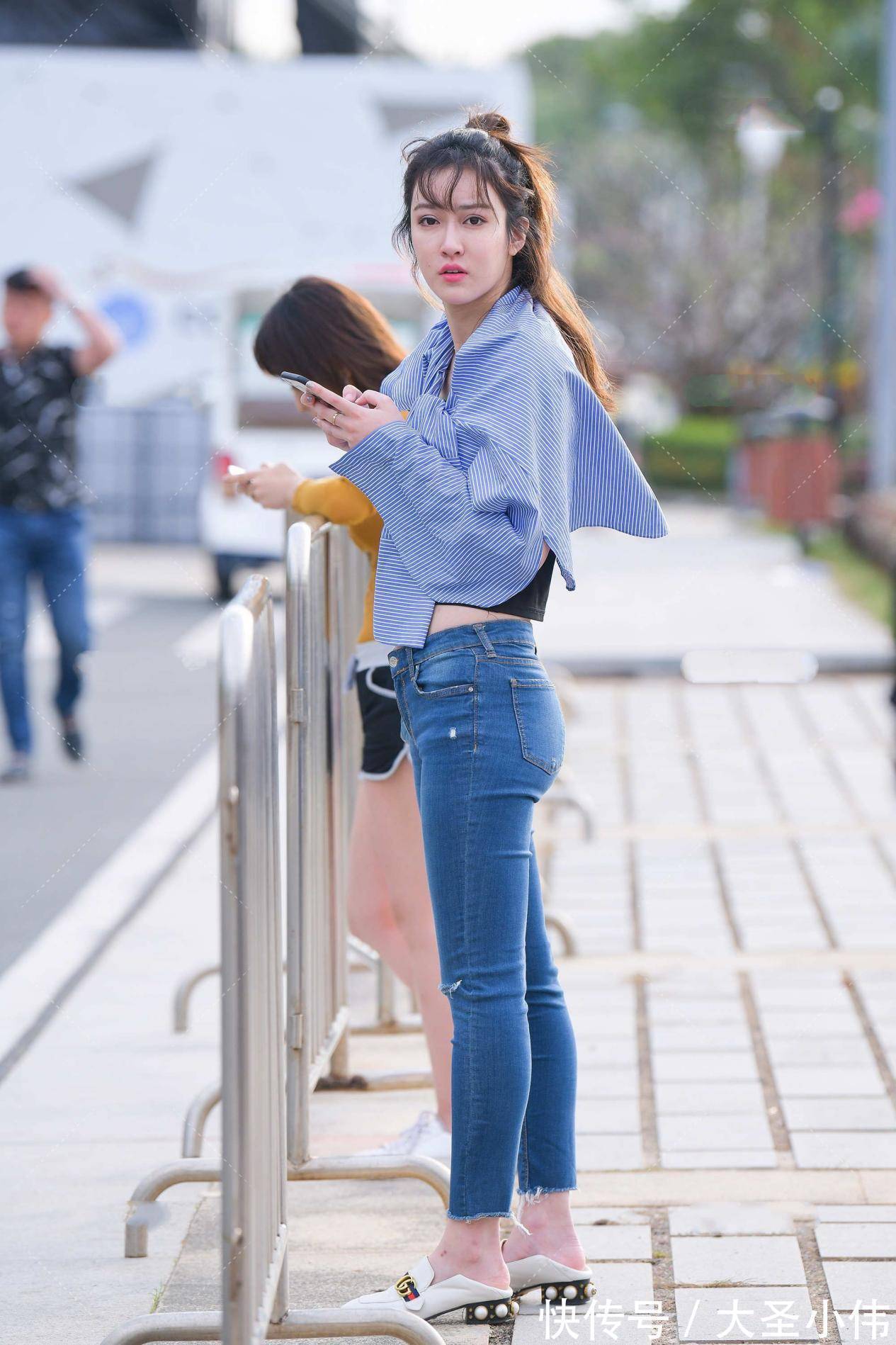 衬衫|美女街拍:蓝色牛仔裤搭配黑色背心,展示好身材,外披一件衬衫防晒又飒爽