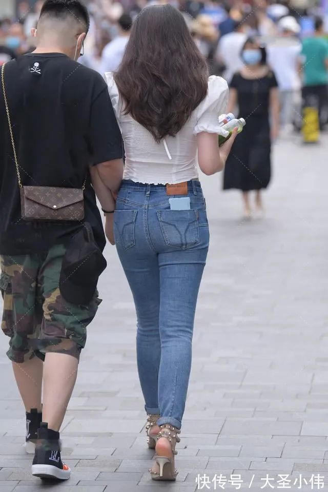 牛仔裤|美女街拍:蓝色紧身牛仔裤,膝盖的破洞很个性,披着牛仔夹克