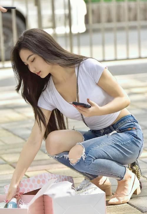 牛仔裤上“凿破洞”,一弯腰膝盖都露出来,美腿藏不住了