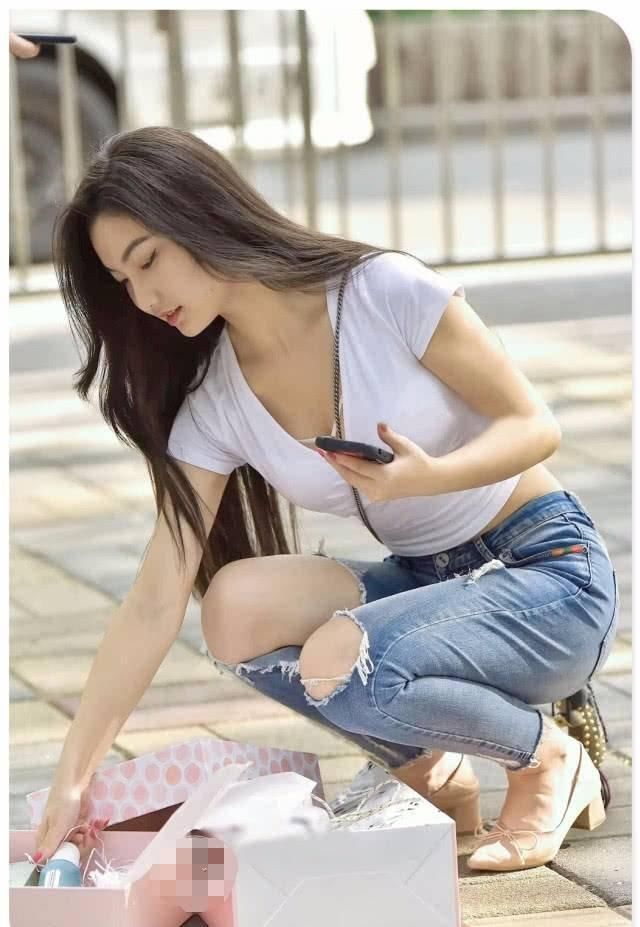街拍美女紧身牛仔裤小姐姐帮人捡起掉落物品，心地善良的女神