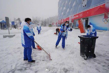 志愿者|冬奥志愿者在冰立方前扫雪铲冰