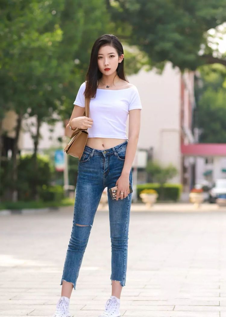 修身牛仔裤 貌美肤白的小姐姐,白色短袖搭配蓝色修身牛仔裤,展现女性风采