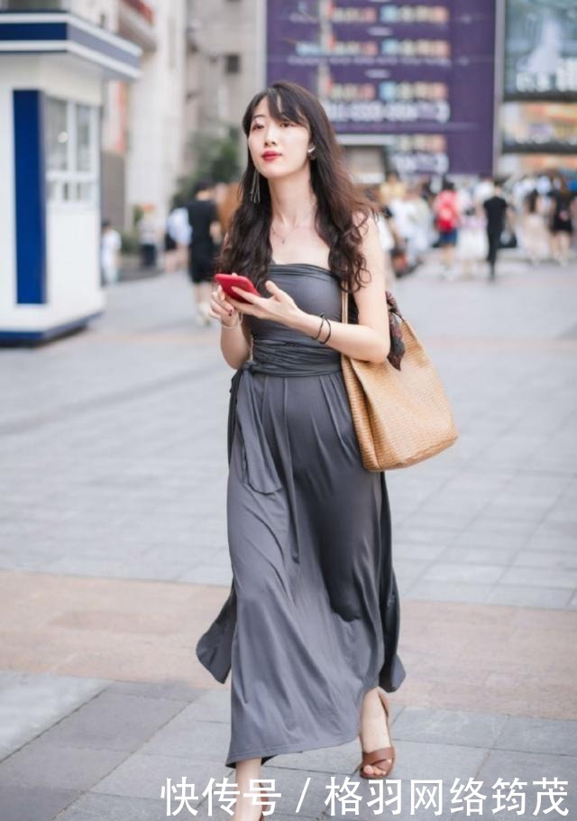 路人街拍,黑色的连衣裙优雅大方,显出一种唯美而又休闲的味道