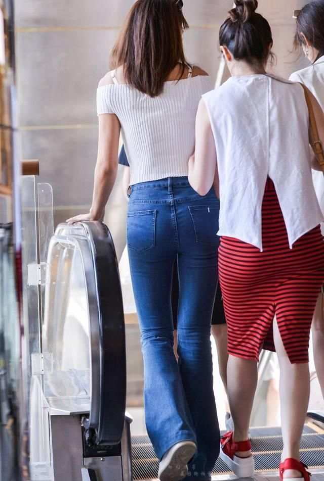 街拍紧身牛仔裤搭配吊带一字肩上衣,小姐姐人长得好看是关键