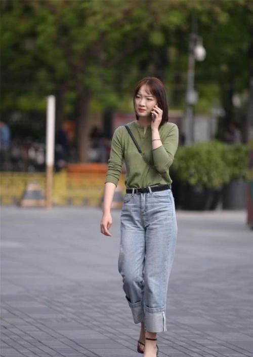 街拍小姐姐绿色针织衫搭配休闲牛仔裤,给人一种美丽优雅的感觉